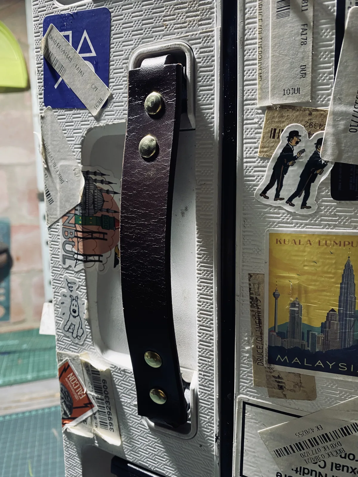 Hand-stitched leather suitcase handle close-up